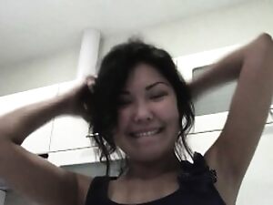 A pretty Asian girl faces a challenge in a restroom, leading to intense hand action and full exposure.